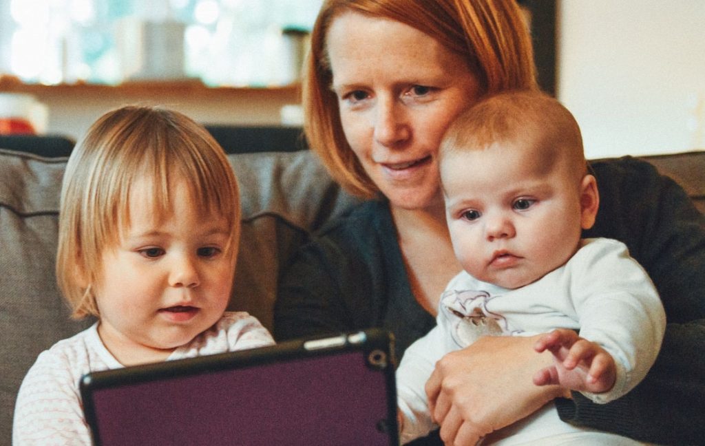A mom and two young children using a tablet